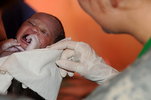 Image of Army Reserve Nurse Delivers Baby in Rural Uganda. Photo by United States Army Africa.